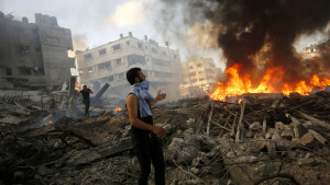 Man inspekterar förödelsen efter bombattacker mot en stadsdel i Gaza. palestinsk man bland bråte i gaza