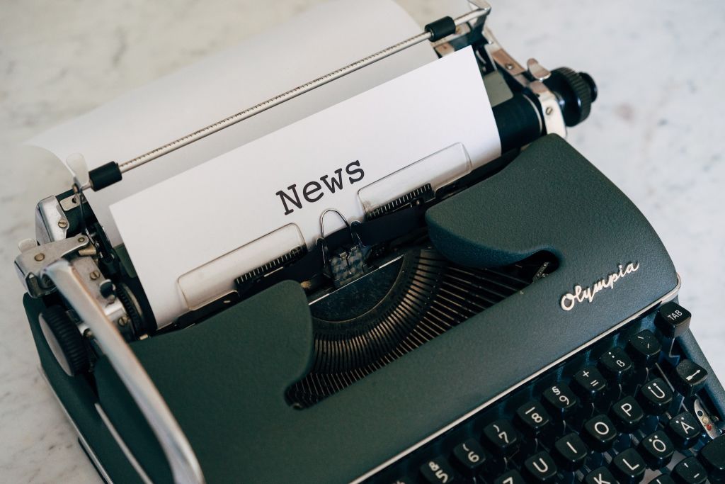 Photo of a typewriter with a piece of paper that says 'News'