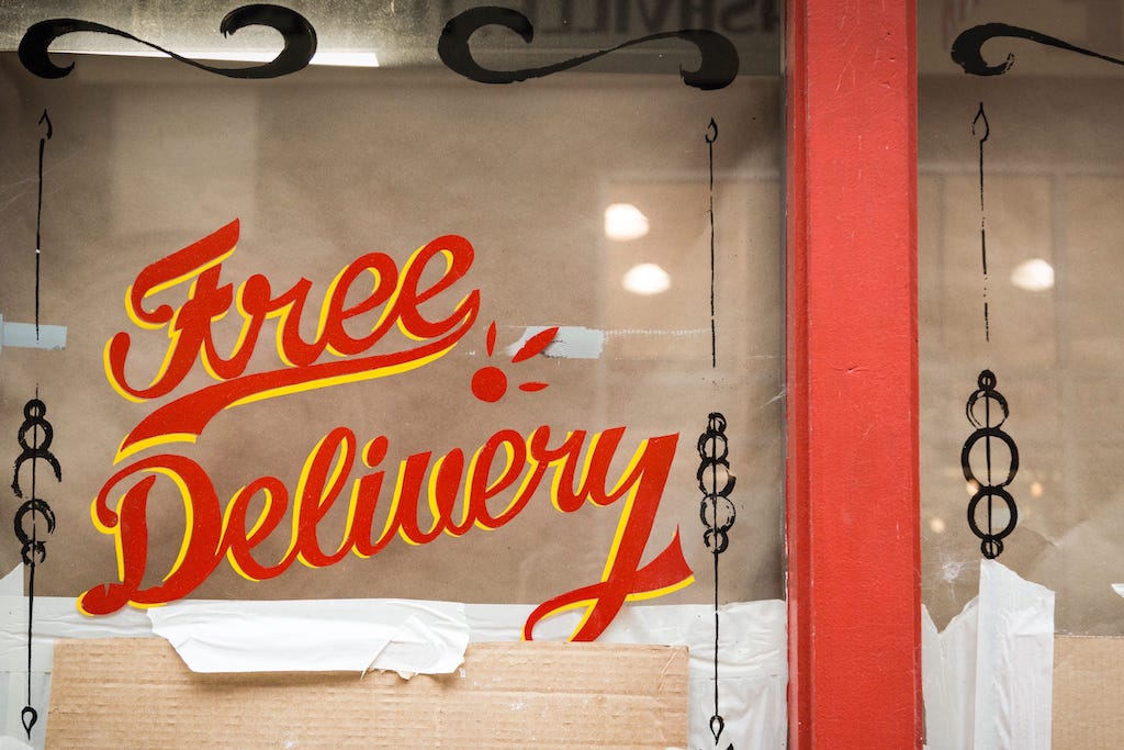 Photo of a window sign saying 'free delivery'