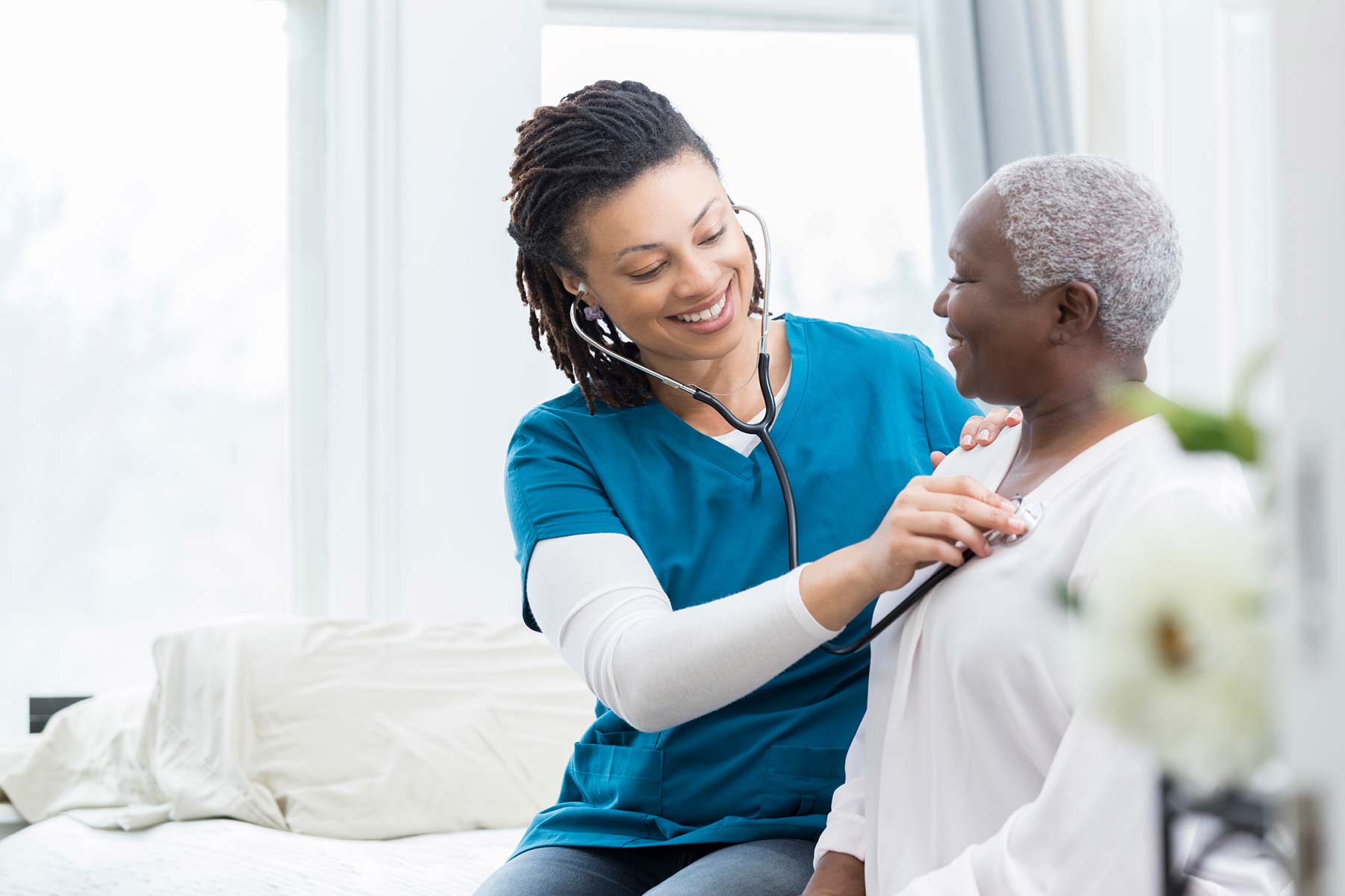 Home Care - provider checking patient with stethoscope