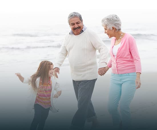 Grandparents and grandchild on the beach.
