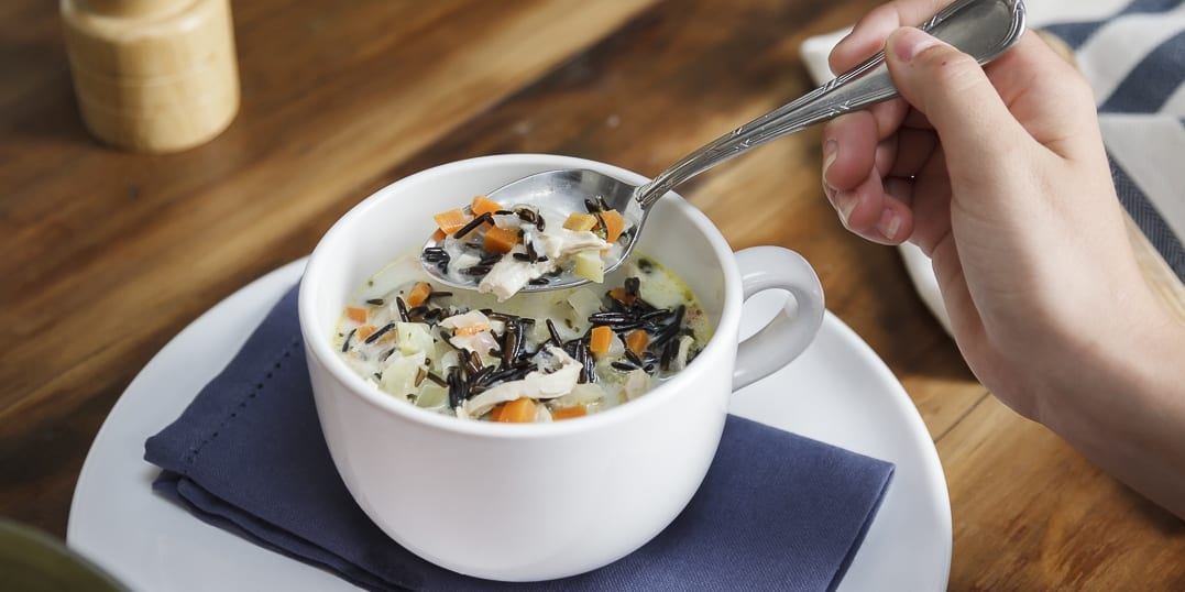 Cup of hearty cream of chicken and wild rice chowder.
