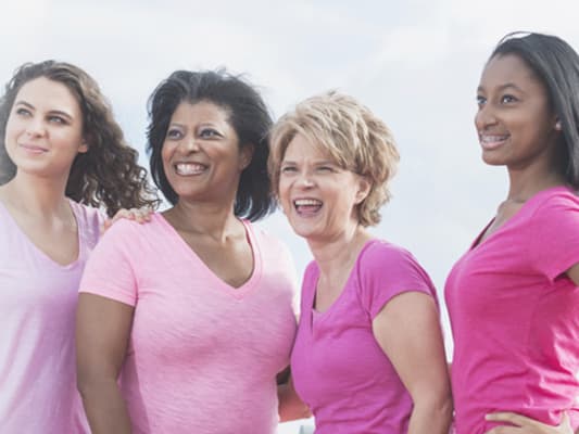 Four women stand strong together.