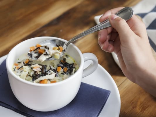 Cup of hearty cream of chicken and wild rice chowder.