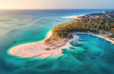 Aerial view of the fishing boats on tropical sea coast with sandy beach at sunset on Zanzibar.jpeg