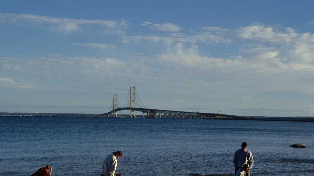 A family walking the shoreline near the Mackinac Bridge. A family walking the shoreline near the Mackinac Bridge.