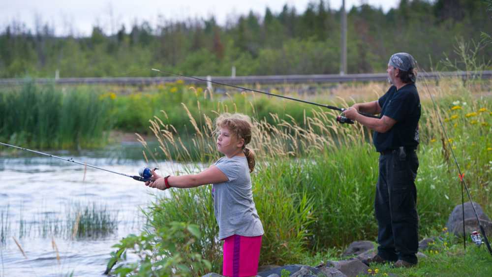 Girl and man fishing on the lakeshore. Girl and man fishing on the lakeshore.