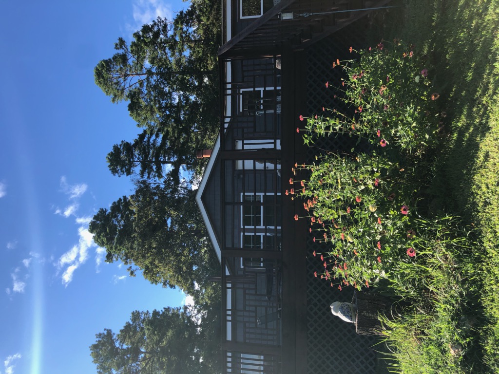 colorful flowers in a circle in front of dark grey house
