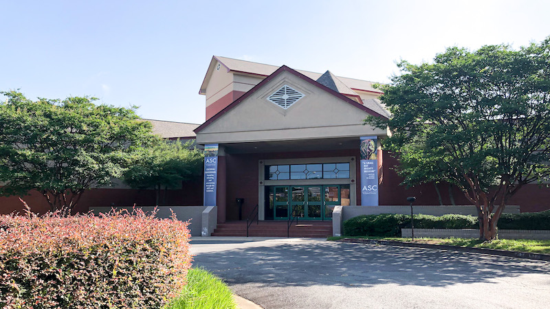 The front of the Arts & Science Center for Southeast Arkansas is shown on a sunny day with manicured landscaping. 