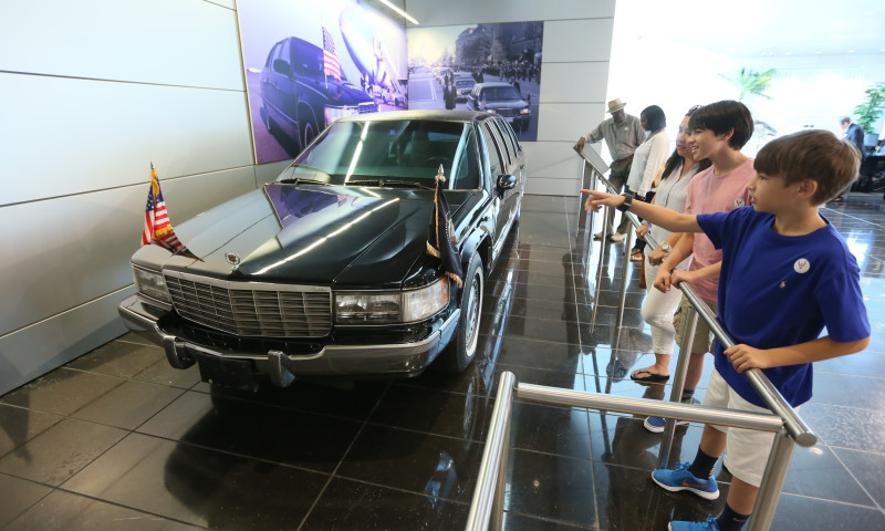 Visitors look at the presidential limousine on display inside the Clinton Presidential Center 