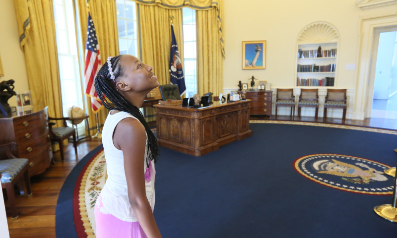 A girl stands inside the full-scale replica of the Oval Office inside the Clinton Presidential Center