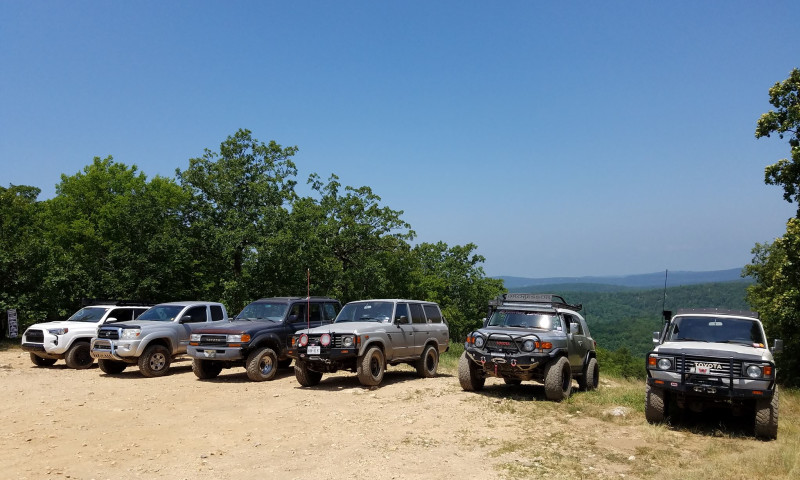 Several different off-road vehicles parked at scenic overlook.