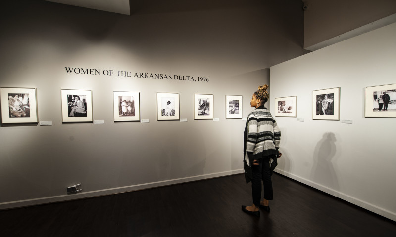 A woman looks at photos of other woman from the Arkansas Delta throughout history. 