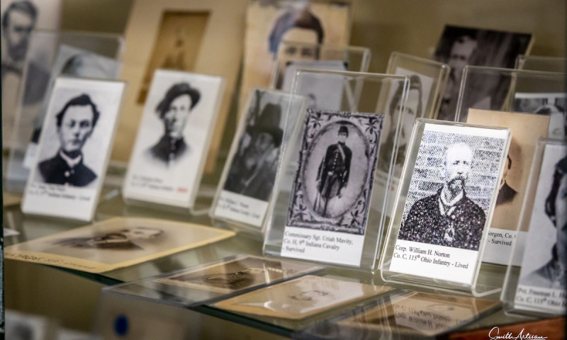 A collection of Civil War photographs is placed individually in stands. Each shows the photo, name and military rank of a Union POW about the Sultana. 