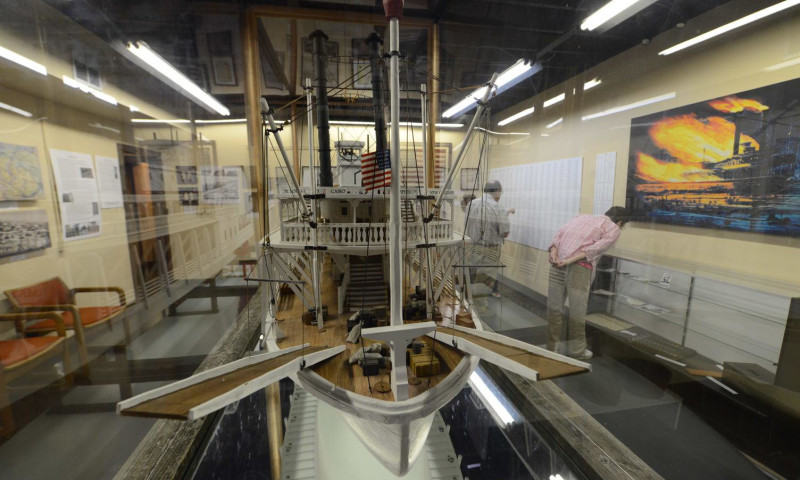 A huge replica of the steamship Sultana is housed in the center of a room, taking up almost all the space. The complex model reaches the ceiling, with details of the original recreated in its artistry. The ship’s American flag is held at half-mast.