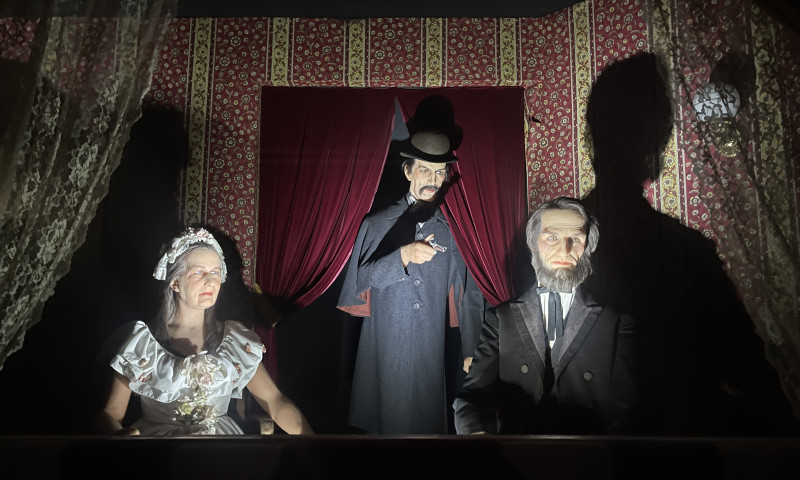 Wax figures of President Lincoln and Mary Todd seated in a theatre booth with John Wilkes Boothe behind them.