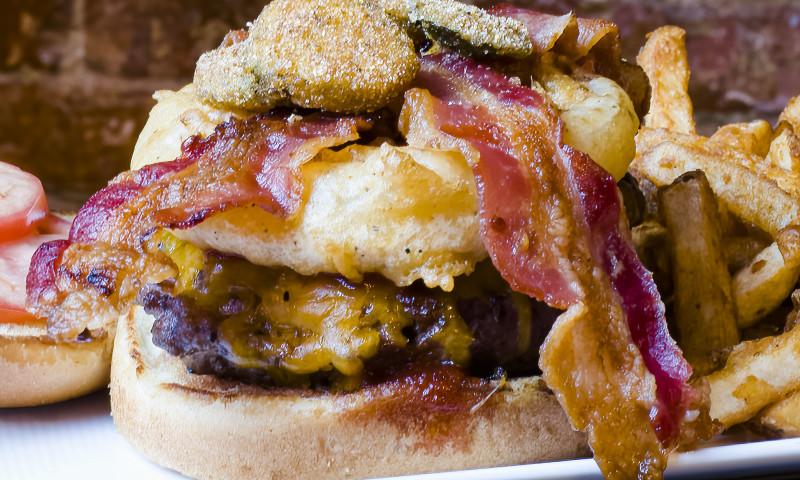 Large burger topped with bacon and fried mushrooms.