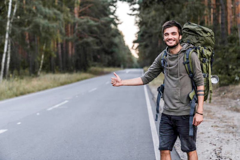image of a person hitchhiking down a road