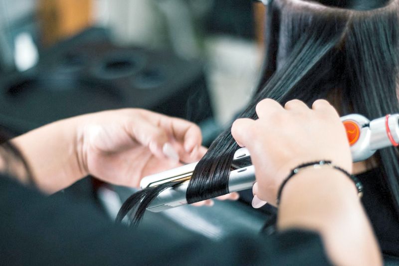 person using a curling iron