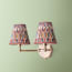 Double insignia wall fixture in antiqued brass