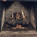 Photo of log set with Holiday decor pieces to break up the flames.