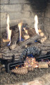 Photo of log set with Holiday decor pieces to break up the flames.