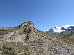18. Schistes lustrés et métabasites du Combin en lits alternés, impliqués dans un pli. Au fond le Mont Rose.