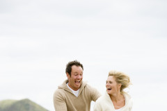 Couple running on beach smiling