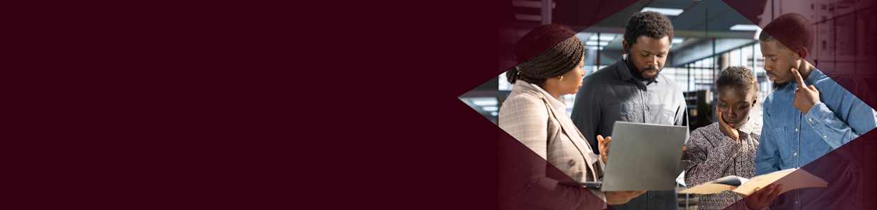 A group of professionals gathered round a desk looking at 3D printing.