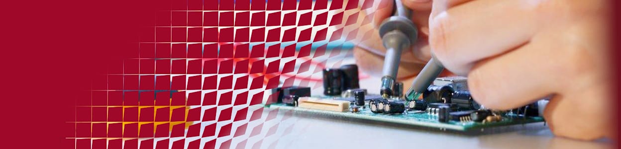 Engineer testing an electronic circuit board using oscilloscope probes while monitoring signal waveforms on a digital oscilloscope.