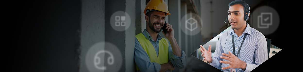Image of two men. First man on the phone wearing hard hat and high vis vest, second man in blue shirt wearing a customer service headset.