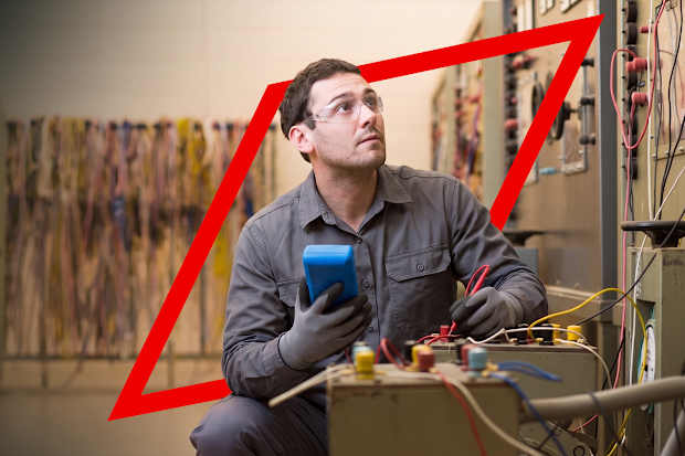 Image of man holding a test and measurement device within an industrial setting