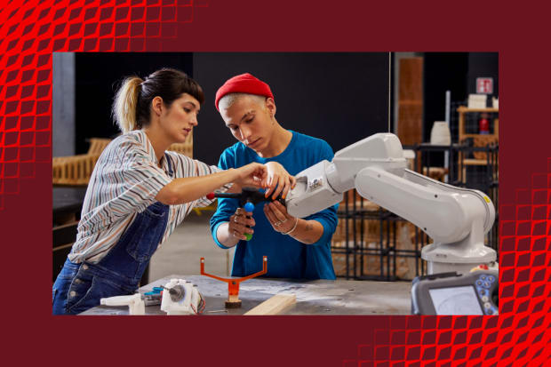 Estudiantes trabajando con un brazo robótico