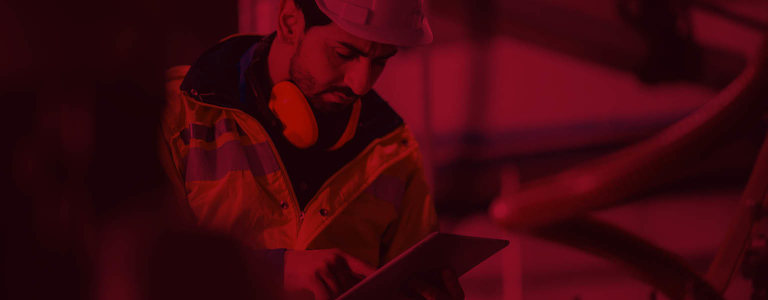 A man in PPE using a tablet to inspect something