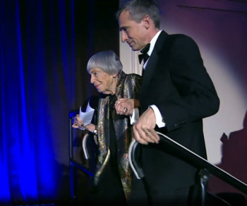 Theo Downes-Le Guin escorts his mother, Ursula Le Guin, on stage