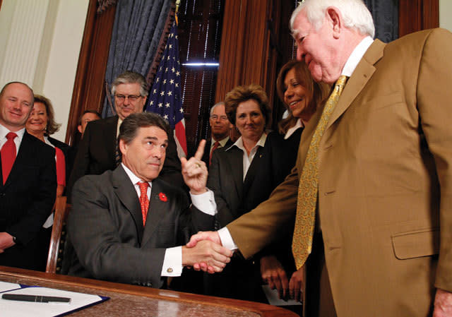 Governor Rick Perry, left, shakes hands with Mike Gallager of Houston after signing a tort reform bill at the Capitol in Austin, Texas on Monday, May 30, 2011.