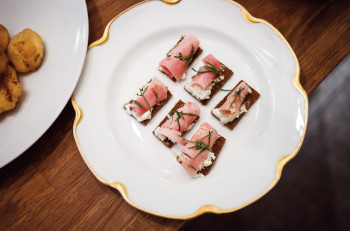Pain d'espices (spice bread) topped with soft cheese, ham, and rosemary