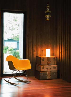 An Eames rocker and vintage suitcases anchor the breezeway.