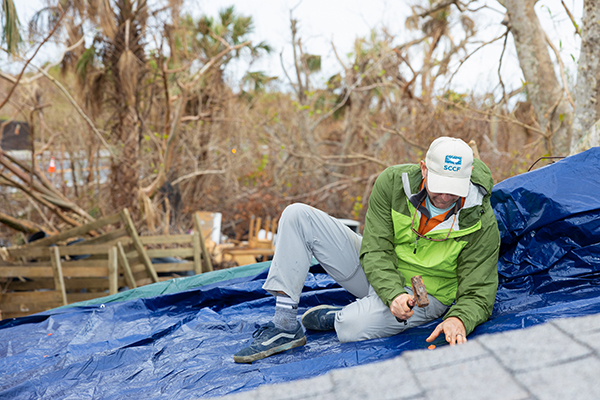 image of person putting tarp on roof
