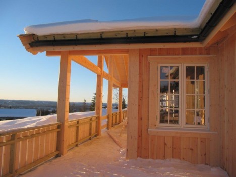 UTVENDIGE DETALJER: Delvis overbygget terrasse, stående falset panel og innramming rundt vinduene er noe vi har spesialbestilt på hytta vår.