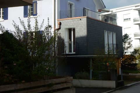 Anbau mit Naturschieferfassade und gleichzeitiger Autounterstand