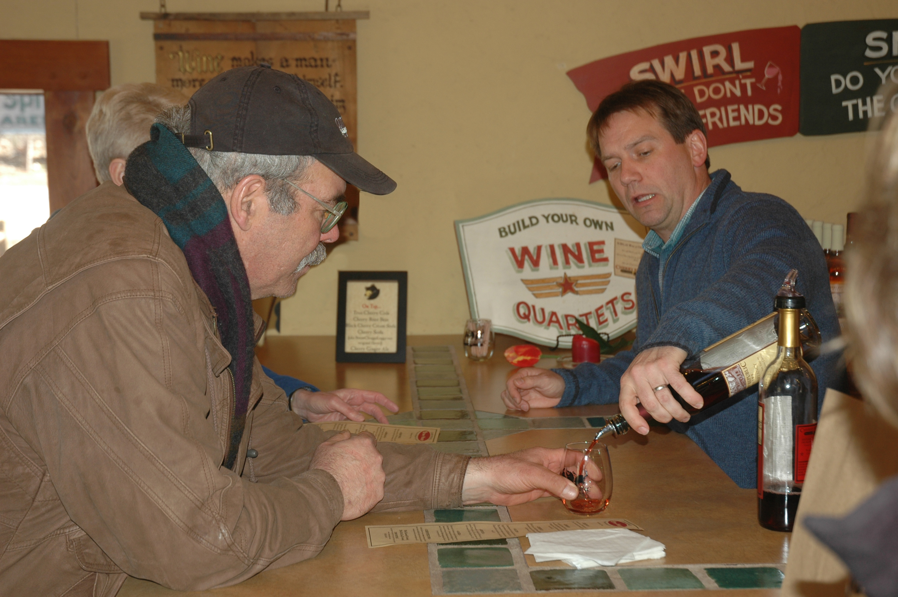 Jason Homa of Cherry Republic pours a sample of their Conservancy wine for Charlie Wunsch of Edible Grand Traverse.