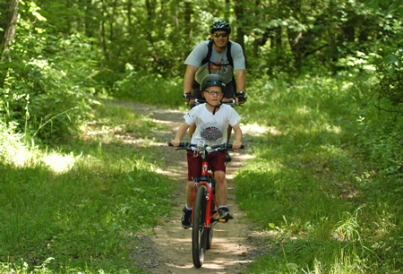 A father and son enjoy a day riding the mountain bike trail at Kent County's Luton Park. The trail was built and is maintained by the West Michigan Mountain Biking Alliance.