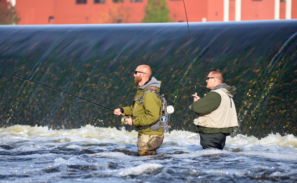 Two area anglers wade-fish for steelhead on the Grand River just downstream from the Sixth Street Dam on the east side of the river. Photo by Howard Meyerson