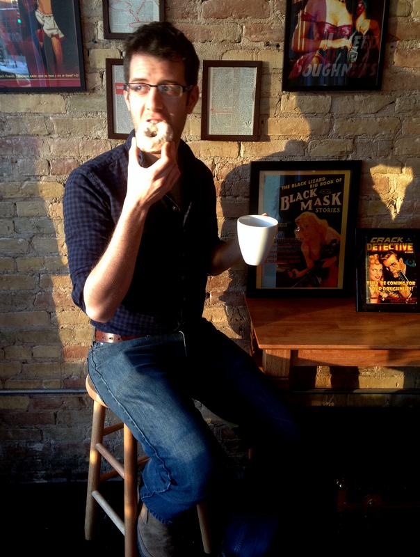 Torrence O'Haire, owner of Propaganda Doughnuts, enjoying a doughnut and coffee.