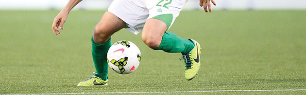 OKC Energy FC Man's feet kicking a soccer ball of the Energy FC