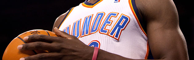 Oklahoma City Thunder Man holding basketball in a Thunder uniform