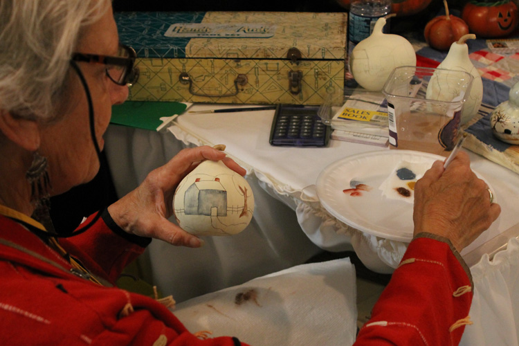 Ann Lankford paints a gourd at her Homestead Primitives shop in Martinsville, Indiana.