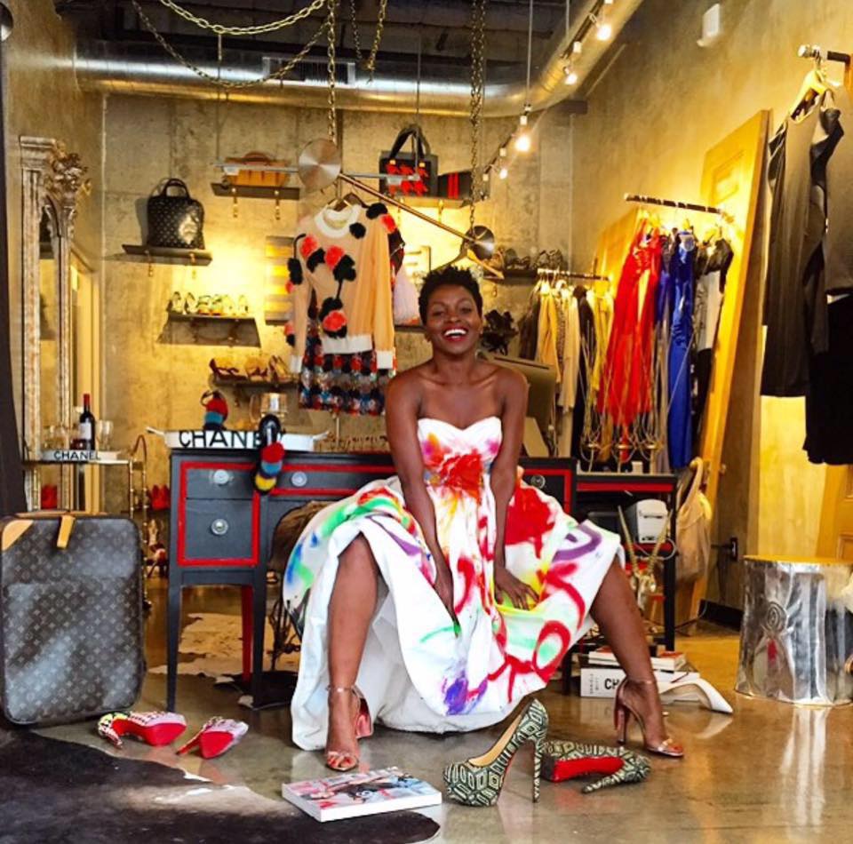 Woman in a colorful dress with shoes and other shopping merchandise