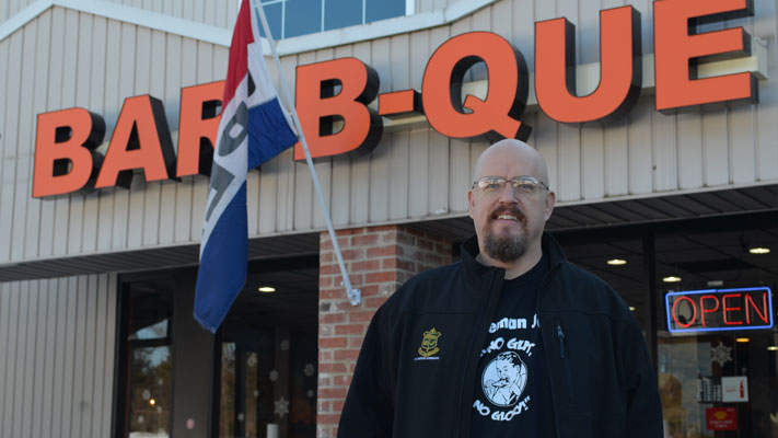 Bob Shoudt poses outside his sponsor, Phamous Phil's BBQ